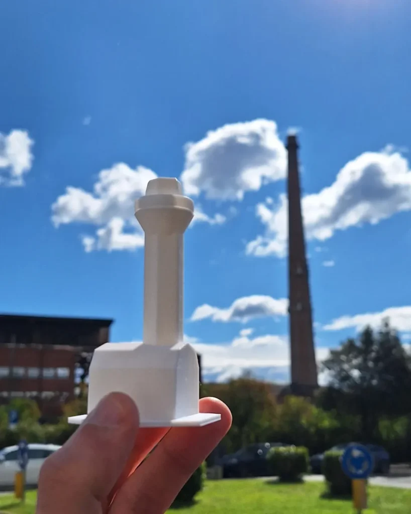In primo piano il totem progettato dai ragazzi della classe di San Nicola la strada, ispirato alla stuttura principale del SaintGobain dismessa, che si intravede sullo sfondo fuori fuoco